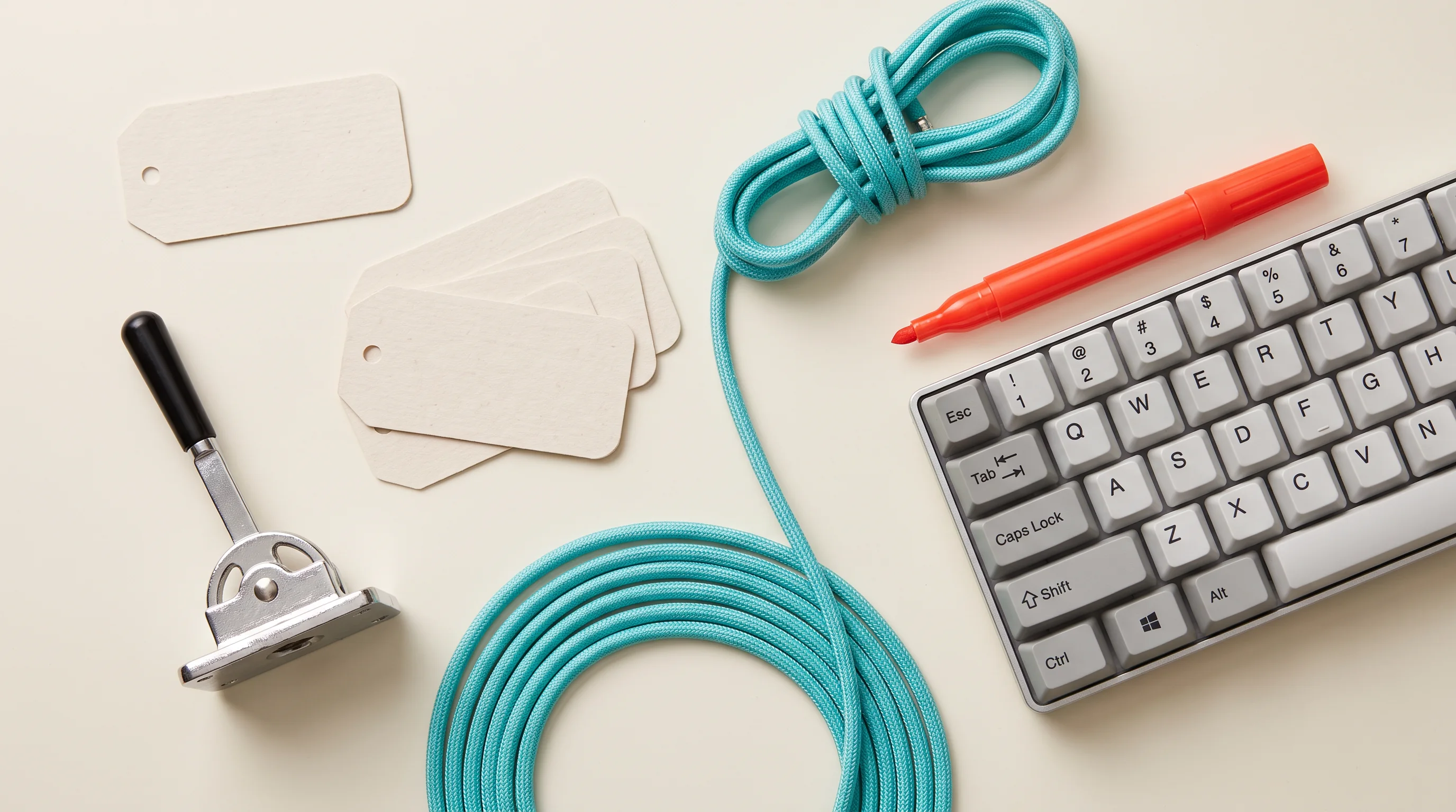 Turquoise cable, keyboard and tags on a light desk